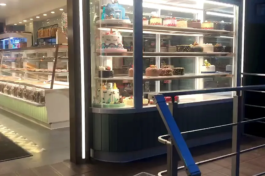 Kent Fırın girişindeki dik pasta teşhir dolabı ve arkasında uzanan camlı teşhir hattı